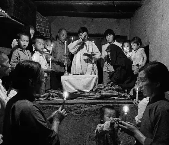 Lu Nan | Kelyje, Katalikų Bažnyčia Kinijoje. Kunigas teikia apeigas sergančiajam, prikaustytam prie lovos. Šaansi provincija, Kinija. 1992. © Lu Nan | Magnum Photos
