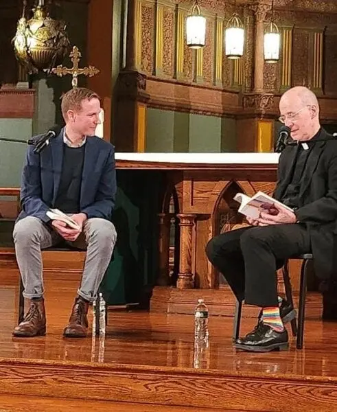 Tėvas Jamesas Martinas su vaivorykštės spalvų kojinėmis per atvirai homoseksualaus „katalikiško“ rašytojo knygos pristatymą