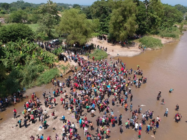 Šimtai imigrantų iš Hondūro kerta sieną upe į Meksiką, 2018.10.29. AFP news agency.